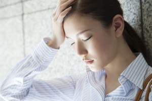 頭をおさえる女性
